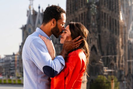 Photo for Multiracial beautiful happy couple of lovers dating on rooftop balcony at Sagrada Familia, Barcelona - Multiethnic people having romantic meeting on a terrace with city view , concepts about tourism and people lifestyle - Royalty Free Image