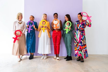 Group of beautiful confident women holding the femininity Venus symbol to celebrate women's day, concepts of women empowerment, women's right and diversity.