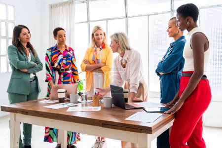 Photo for Group of beautiful confident businesswomen meeting in the office - Multiethinc female creative team brainstorming at work - Diverse colleagues working together  in workshop  in a co-working space - Royalty Free Image