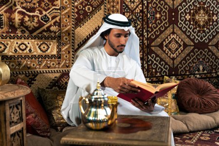 Foto de Hombre de emirati con traje de kandura pasando tiempo en una casa tradicional árabe en Dubai - Imagen libre de derechos