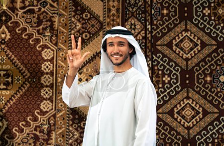 Photo for Man from emirati wearing kandura outfit spending time in an arabian traditional house in Dubai - Royalty Free Image