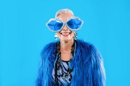 Téléchargez les photos : Vieille femme âgée heureuse et drôle portant des vêtements fashinable sur fond coloré- moderne cool portrait fantaisie grand-mère, concepts sur les personnes âgées et les personnes âgées - en image libre de droit