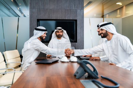Grupo de empresarios árabes corporativos reunidos en la oficina - Empresarios de Oriente Medio que usan emirati kandora trabajando en una sala de reuniones, Dubai