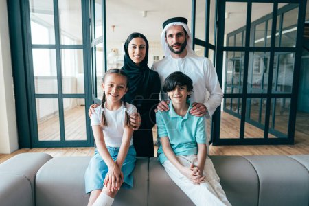 Téléchargez les photos : Famille arabe traditionnelle de Dubaï passer du temps ensemble à la maison. Concept, culture emirati, parentalité, adoption et mode de vie familial - en image libre de droit