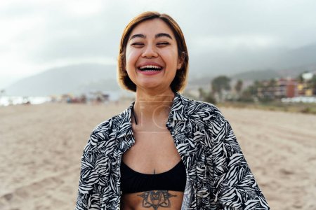 Téléchargez les photos : Portrait de belle asiatique jeune femme souriante à la plage au coucher du soleil - en image libre de droit