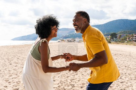 Foto de Hermosa pareja negra madura de amantes citas en la playa - Casado africano de mediana edad pareja vinculación y divertirse al aire libre, conceptos sobre la relación, el estilo de vida y la calidad de vida - Imagen libre de derechos