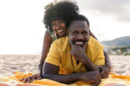 Photo for Beautiful mature black couple of lovers dating at the seaside - Married african middle-aged couple bonding and having fun outdoors, concepts about relationship, lifestyle and quality of life - Royalty Free Image