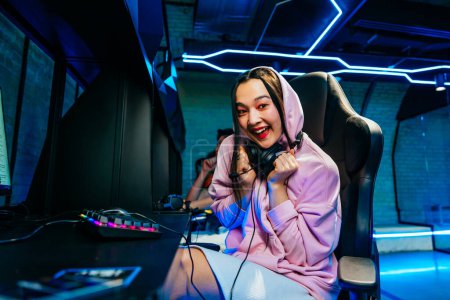 Foto de Hermosa joven asiática mujer jugando videojuegos en un cibercafé - Videogamer divertirse jugando e-sports en la consola de videojuegos de ordenador - Imagen libre de derechos