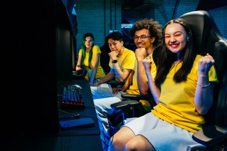 Foto de Grupo multiétnico de jóvenes amigos jugando videojuegos - Equipo de jugadores profesionales de esport que juegan en videojuegos competitivos en un torneo de juegos cibernéticos - Imagen libre de derechos