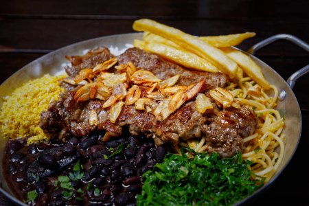 Foto de Cocina brasileña: carne, arroz y patatas fritas con papas fritas. - Imagen libre de derechos