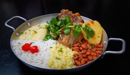 Foto de Plato brasileño de ternera, rabo de buey con berro, frijoles, farofa, arroz y pimienta - Imagen libre de derechos