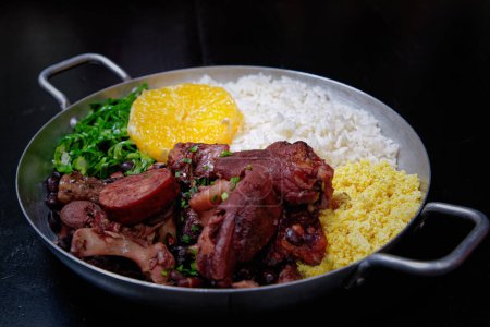 Foto de Feijoada brasileña con salchicha, col, arroz y naranja - Imagen libre de derechos