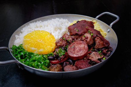 Photo for Brazilian feijoada with sausage, cabbage, rice and orange - Royalty Free Image
