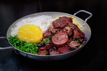 Photo for Brazilian feijoada with sausage, cabbage, rice and orange - Royalty Free Image