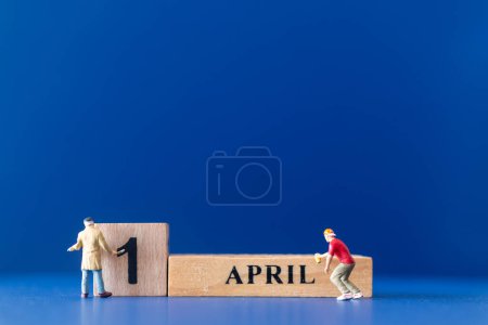 Photo for Miniature people painting a wooden block on April 1st, april fools day concept - Royalty Free Image