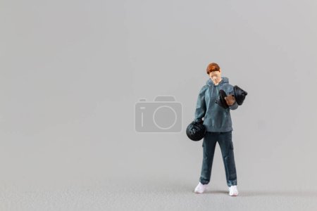 Téléchargez les photos : Personnes miniatures, ajustement des poids de levage de jeune homme sur fond gris - en image libre de droit