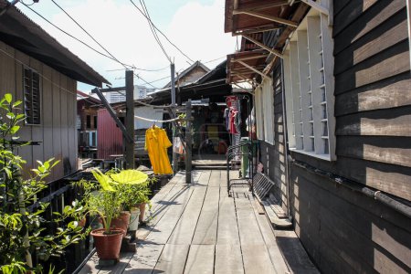 Photo for Georgetown, Penang, Malaysia - November 2012: A wooden walkway through traditional stilt houses in the Clan jetties of a waterside village in George Town. - Royalty Free Image