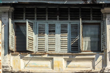 Téléchargez les photos : Georgetown, Penang, Malaisie - Novembre 2012 : Détail des fenêtres rectangulaires en bois brun d'une ancienne maison de commerce vintage dans la ville patrimoniale de Penang. - en image libre de droit
