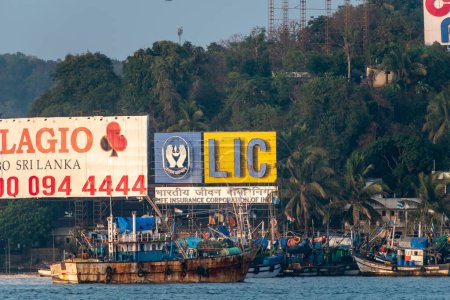 Photo for Panjim, Goa, India - January 2023: Large advertising hoarding of LIC and other companies at the riverside fishing port of Porvorim in Goa. - Royalty Free Image