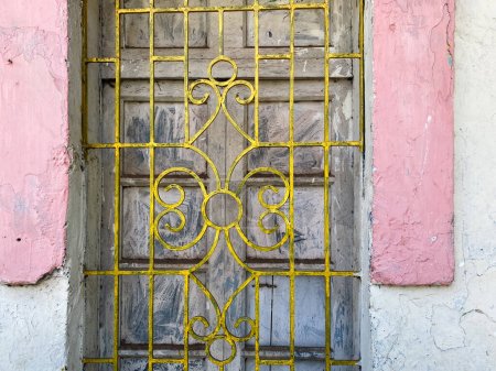 Photo for Detail of ironwork on the grille of a vintage window of an old house in the Fontainhas area of Panjim in Goa. - Royalty Free Image