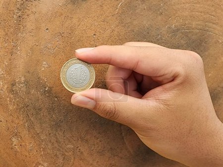 Photo for Hand of a man holding a turkish coin of one lira - Royalty Free Image