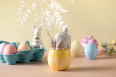 Festliche Osterkomposition mit einem Hasen im Osterei auf floralem Hintergrund. Frohe Ostern