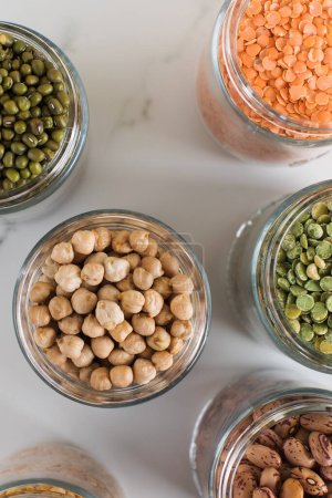 Legumes in glass jars top view. The concept of vegetable protein, vegetarianism, healthy eating.