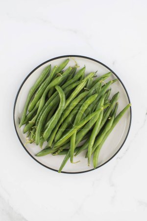 Foto de Las judías verdes están crudas en un plato. El concepto de alimentación saludable. - Imagen libre de derechos