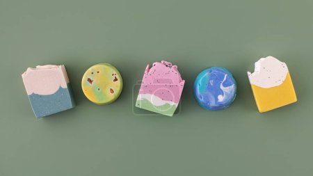 Photo for Pieces of different shapes and colors of handmade soap on a green background. The concept of natural cosmetics, hygiene. Banner - Royalty Free Image