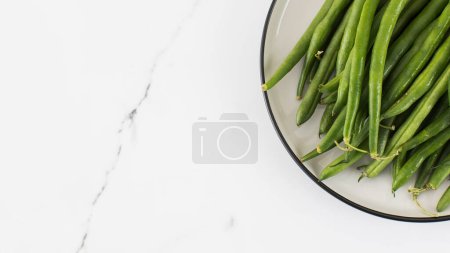 Foto de Las judías verdes están crudas en un plato. El concepto de alimentación saludable. Copiar espacio - Imagen libre de derechos
