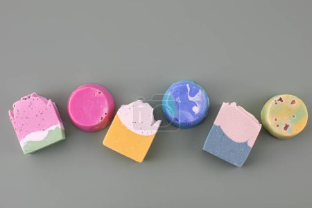Foto de Piezas de diferentes formas y colores de jabón hecho a mano sobre un fondo verde. El concepto de cosmética natural, higiene. Banner - Imagen libre de derechos