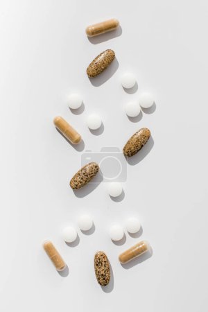 Téléchargez les photos : Une variété de pilules et de vitamines sur fond blanc. Le concept de médecine, les médicaments. - en image libre de droit