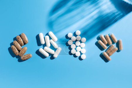 Verschiedene Vitamine, Tabletten und Nahrungsergänzungsmittel auf blauem Hintergrund. Das Konzept der Medizin.