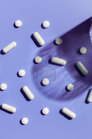 Téléchargez les photos : Diverses vitamines et pilules sur fond violet. Le concept de médecine, de traitement et de santé. - en image libre de droit