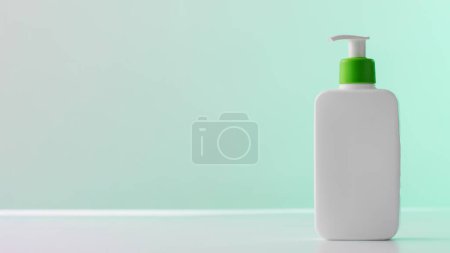 Photo for Ad-ready banner with a sleek, white cosmetic bottle and green pump, set against a teal backdrop with ample space for branding and text. Skin care - Royalty Free Image