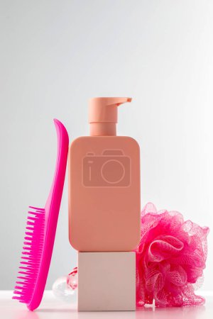 Chic pink dispenser with shampoo or gel on podium, ideal for spa branding with copy space. Skin care
