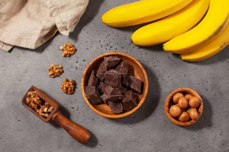 Würfel dunkler handwerklicher Schokolade. Dekadente dunkle Schokolade, Walnüsse und Bananen präsentieren ein Fest der Aromen und Texturen. 