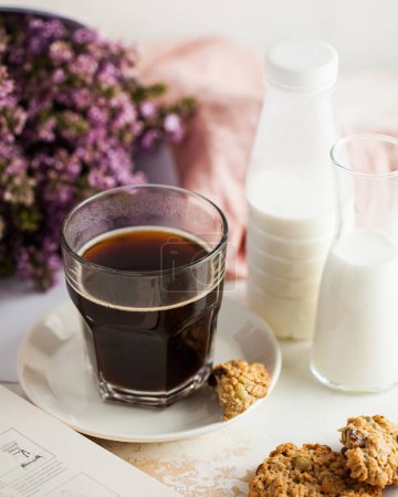 Coffee. Morning coffee bliss with cream and cookies, set against soft lilac blooms.