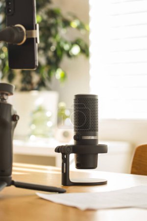 Podcast-Mikrofonaufbau auf einem Holztisch, warmes Licht. Das Konzept der Aufnahme eines Podcasts, Streamers