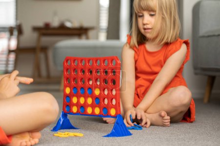 Cute little girl strategizing in Connect Four. Concept of Logic game
