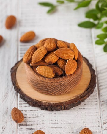 Organic raw almonds in a rustic wooden bowl, perfect for a healthy and nutritious snack. Nuts