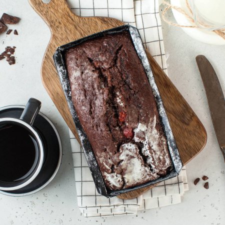 Rich and moist chocolate loaf cake, dusted with powdered sugar, perfect for a decadent dessert or teatime treat