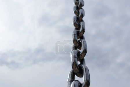 Photo for Steel chain with clouds on sky on background - Royalty Free Image