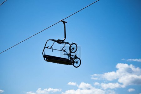 Téléchargez les photos : Vélo fixe sur télésiège vide avec ciel bleu en arrière-plan - en image libre de droit