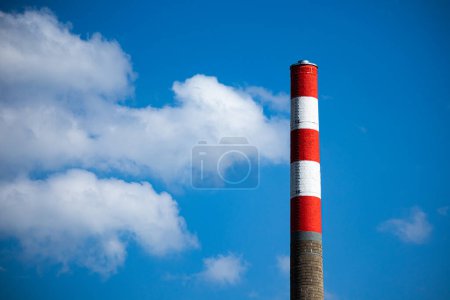 Téléchargez les photos : Cheminée avec peinture blanche et rouge sur fond bleu ciel - en image libre de droit