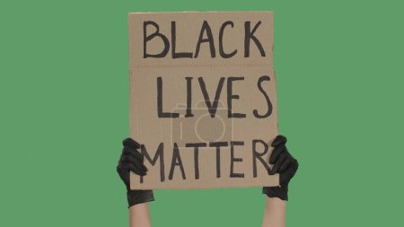 Foto de Las manos de una persona desconocida con guantes negros levantan el cartel de cartón. Stop Racism concept, No Racism. Reuniones contra el racismo y la brutalidad policial. La vida pacífica de los negros importa - Imagen libre de derechos