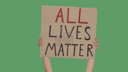 Photo for Hands of women raising up cardboard poster ALL LIVES MATTER. Stop Racism concept, No Racism. Rallies against racism and discrimination. Peaceful life of blacks matters. Isolated green screen chroma - Royalty Free Image