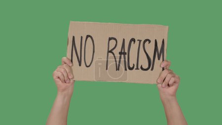 Photo for NO RACISM. Protest text message on cardboard. Stop racism. Police violence. Banner design concept. Hands of men raising up poster on green screen, chroma key. Rallies against racism and police - Royalty Free Image