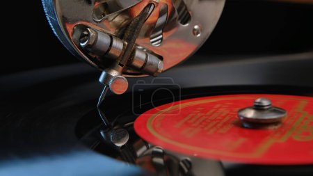 Photo for Vintage old record player gramophone needle on vinyl record. Round shiny metal needle reproducing music, sliding along grooves of the record. Macro shot of retro vinyl player on black studio - Royalty Free Image
