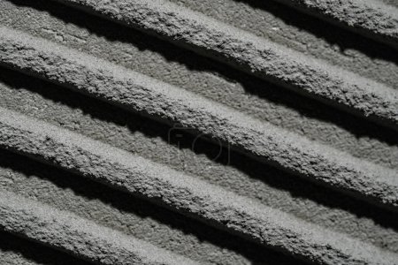 Foto de Tetrtura de hormigón fresco con patrones de llana entallada. Macro plano de masilla de cemento de superficie gris en la pared con líneas o rayas. Pasta de mortero adhesivo desigual para baldosas cerámicas. Instalación de azulejos - Imagen libre de derechos